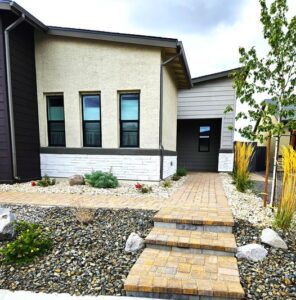 Front entry way with new cobble style paver walkway, river rocks, larger rocks and DG. Xeriscape style with small shrubs and Northern Nevada native trees. 